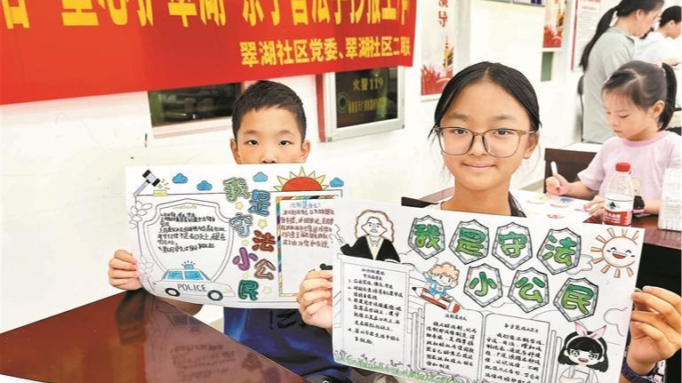 光明翠湖社区亲子共同制作普法手抄报